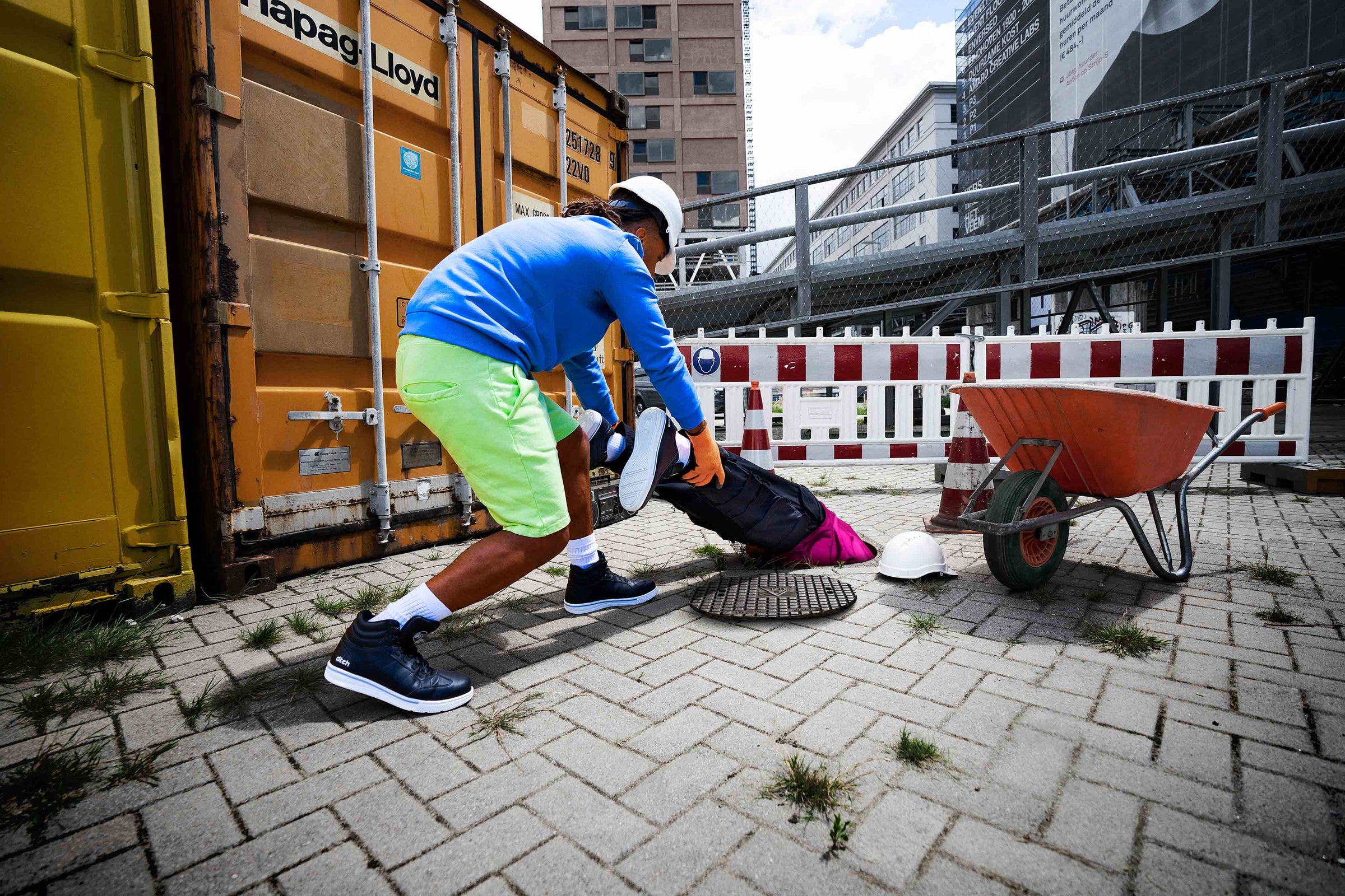Veiligheidsschoenen sneakers van DTCH, dames en heren werkschoen aan de voeten van werkende jongeren die veilig werken.